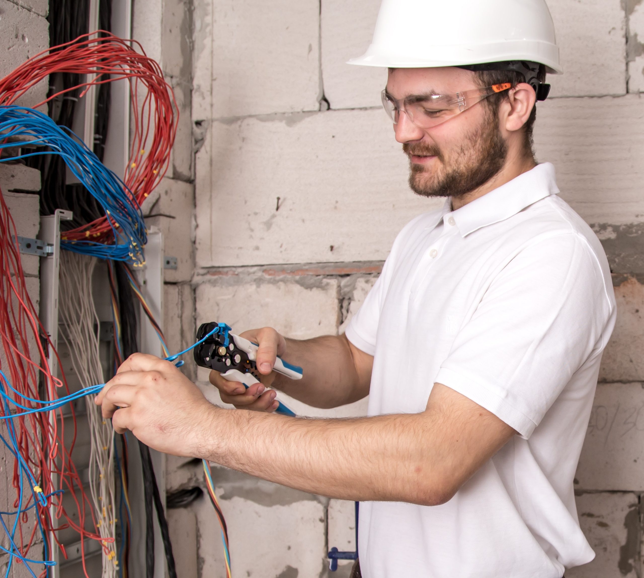 Electrician working near the Board with wires. Installation and connection of electrics.